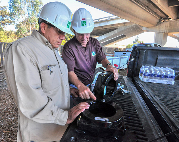 two men with hard hats installing cable to a Vista pad mount unit, parts, technical support Parts & Technical Support, vista, pad mount, installation of metal clad, installing environmentally friendly metal clad, distribution switchgear